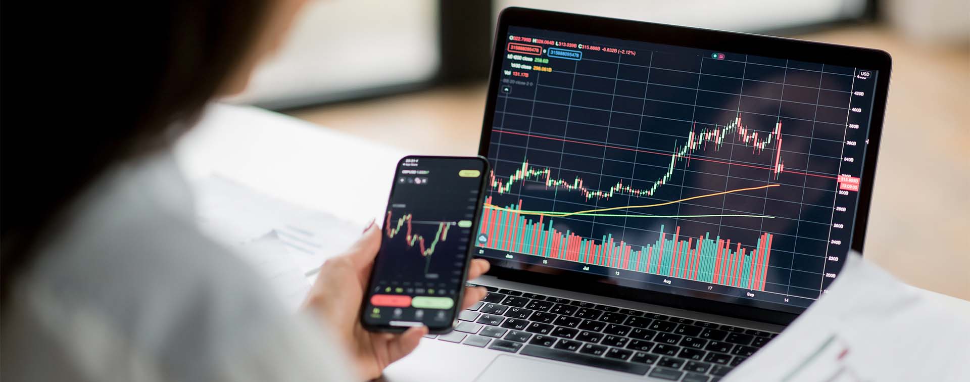 woman investor and crypto trader, using laptop and smartphone